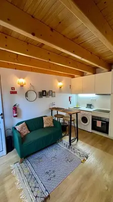 a living room with a green couch and a table at Mezzanine cozy house in Porto