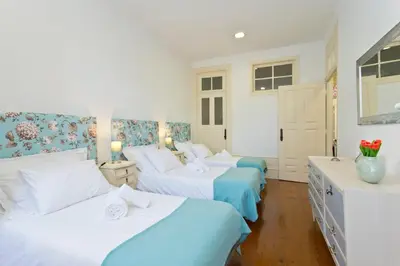 three beds in a room with blue and white at Casa Portugueza Experience in Porto