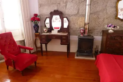 a living room with a chair and a table and a fireplace at Casa Portugueza Experience in Porto