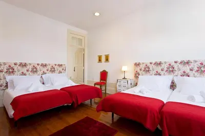 two beds in a room with red and white at Casa Portugueza Experience in Porto