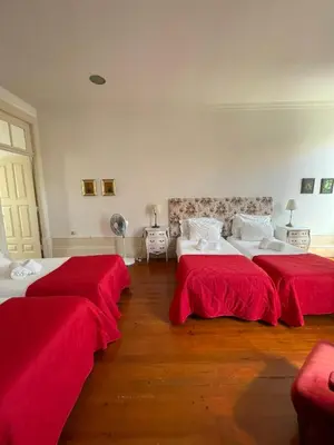 two beds in a room with red sheets at Casa Portugueza Experience in Porto