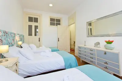 a bedroom with three beds and a dresser at Casa Portugueza Experience in Porto