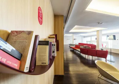 a shelf with books on a wall in a room at Moov Hotel Porto Centro in Porto