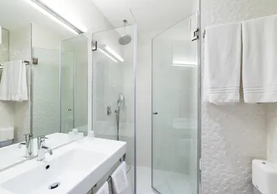 a bathroom with a sink and a glass shower at Moov Hotel Porto Centro in Porto