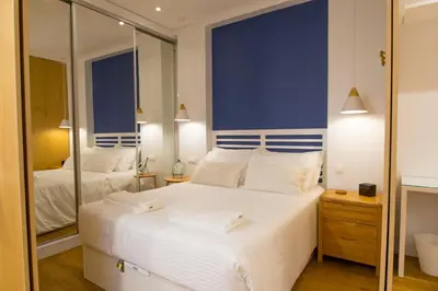 a bedroom with a large white bed and a mirror at Merc Porto Cedofeita Place in Porto