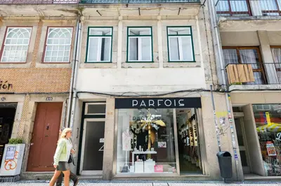 a woman walking in front of a parolis store at Merc Porto Cedofeita Place in Porto