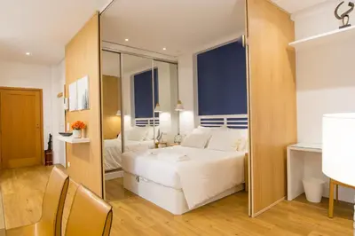 a bedroom with a large white bed and a mirror at Merc Porto Cedofeita Place in Porto
