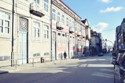 a person walking down a street next to a building at A Casa da Maria in Porto