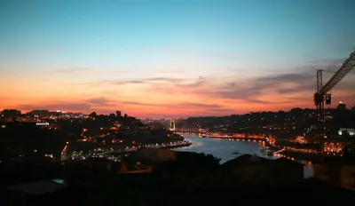 a view of a river at sunset at APOSENTUS - Your home with a remarkable view in Vila Nova de Gaia