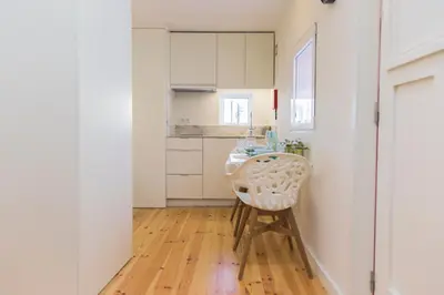 a kitchen with a table and a chair in a room at APOSENTUS - Your home with a remarkable view in Vila Nova de Gaia