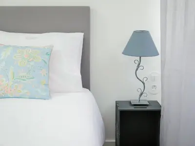 a bed with a pillow and a lamp on a night stand at CM Vintage Apartments in Porto