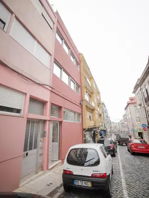 a white car parked in front of a pink building at CM Vintage Apartments in Porto