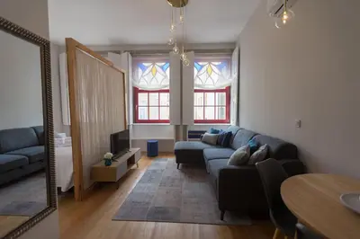 a living room with a couch and a tv at charm in C - Porto Center Apartment in Porto