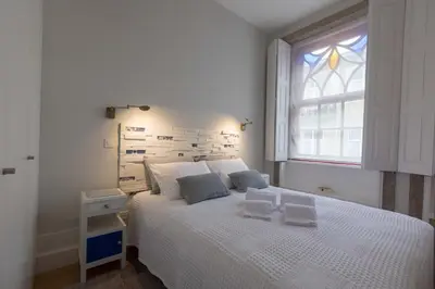 a bedroom with a white bed with a window at charm in C - Porto Center Apartment in Porto