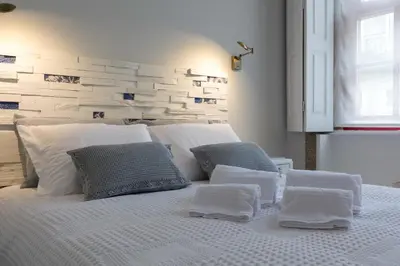 a bedroom with a white bed with pillows on it at charm in C - Porto Center Apartment in Porto