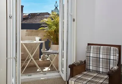 a room with a balcony with a chair and a table at Downtown Colosseum Apartments in Porto
