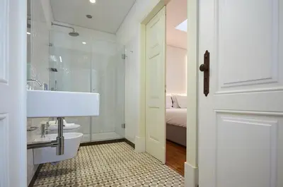 a white bathroom with a sink and a toilet at Downtown Colosseum Apartments in Porto