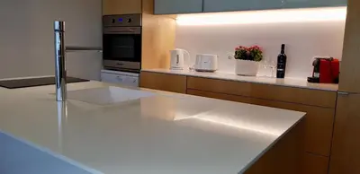 a kitchen with a white counter top with a bottle of wine at Min Porto Inn in Porto
