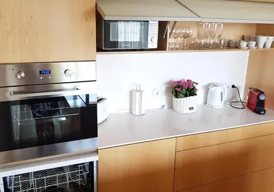 a kitchen with stainless steel appliances and wooden cabinets at Min Porto Inn in Porto
