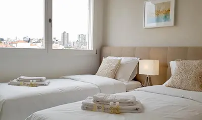 a room with three beds with white sheets and a window at Min Porto Inn in Porto