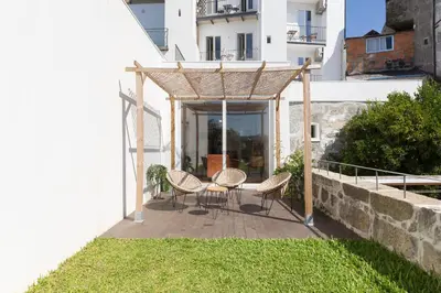 a patio with chairs and a table on a building at Douro Virtudes Apartments Historical Center in Porto