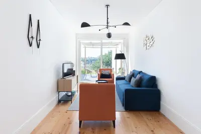 a living room with a blue couch and a tv at Douro Virtudes Apartments Historical Center in Porto
