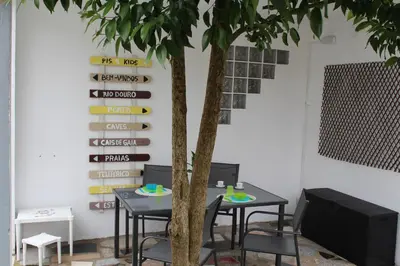 a table and chairs next to a tree in a room at Porto In Sight, 4 Kids in Vila Nova de Gaia