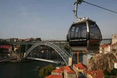 a cable car flying over a bridge over a river at Porto In Sight, 4 Kids in Vila Nova de Gaia