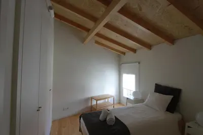 a bedroom with a bed in a room with wooden ceilings at Oporto City Cottage in Porto