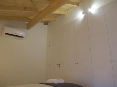 a bedroom with white walls and wooden ceilings at Oporto City Cottage in Porto