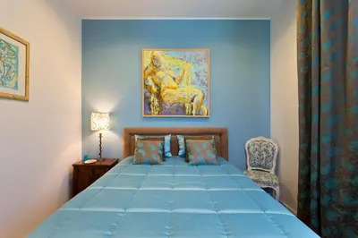 a blue bedroom with a bed and a chair at Luxurious Pink House and Parking in Porto