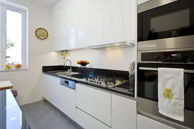 a white kitchen with a stove and a sink at Luxurious Pink House and Parking in Porto
