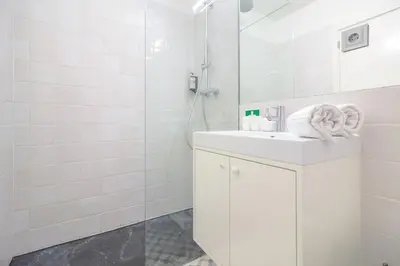 a white bathroom with a sink and a shower at YOUROPO - The Tower in Porto