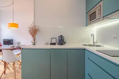 a kitchen with blue cabinets and a table at YOUROPO - The Tower in Porto