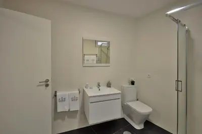 a white bathroom with a toilet and a sink at Casa da Ana - Porto Velho Apt in Porto