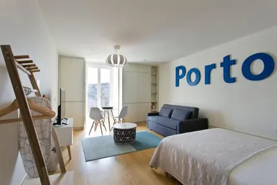 a bedroom with a bed and a blue couch at Vitoria Studio Residence - Downtown in Porto