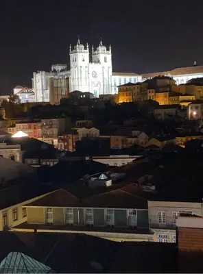 a lit up building in the city at night at Vitoria Studio Residence - Downtown in Porto