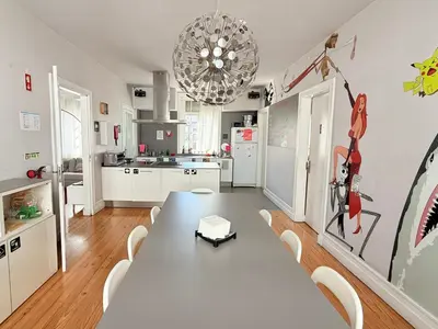 a dining room with a table and a kitchen at Rivoli Cinema Hostel in Porto