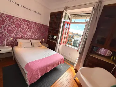 a small bedroom with a bed and a window at Rivoli Cinema Hostel in Porto