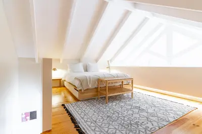 a bedroom with a bed and a large window at Casulo Loft - Oporto Downtown in Porto