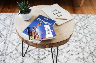 a round wooden table with books and a pen on it at Casulo Loft - Oporto Downtown in Porto