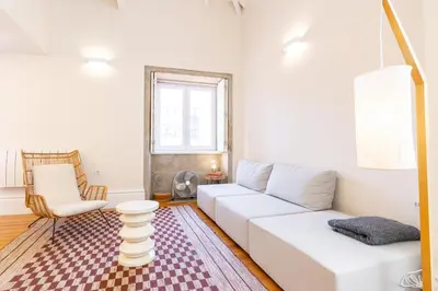 a living room with a white couch and a chair at Casulo Loft - Oporto Downtown in Porto