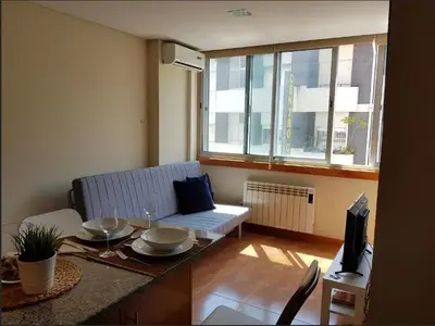 a living room with a couch and a table at Cosy Santa Catarina Flat in Porto