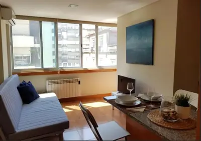 a living room with a table and a couch at Cosy Santa Catarina Flat in Porto