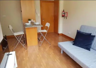 a living room with a couch and a table with chairs at Cosy Santa Catarina Flat in Porto