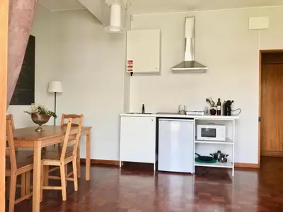 a kitchen and dining room with a table and a microwave at Boavista YourHome in Porto