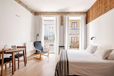 a hotel room with a bed and a table and a chair at Belomonte 22 Apartments Porto World Heritage in Porto