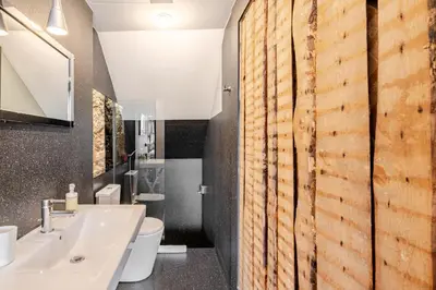 a bathroom with a white sink and a wooden wall at Belomonte 22 Apartments Porto World Heritage in Porto