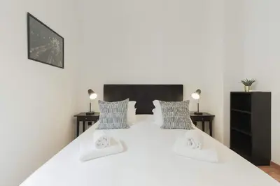 a bedroom with a large white bed with two night stands at Puro Apartment in Porto
