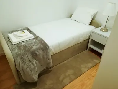 a bedroom with a bed and a nightstand with a white mattress at Nightingale Apartments in Porto